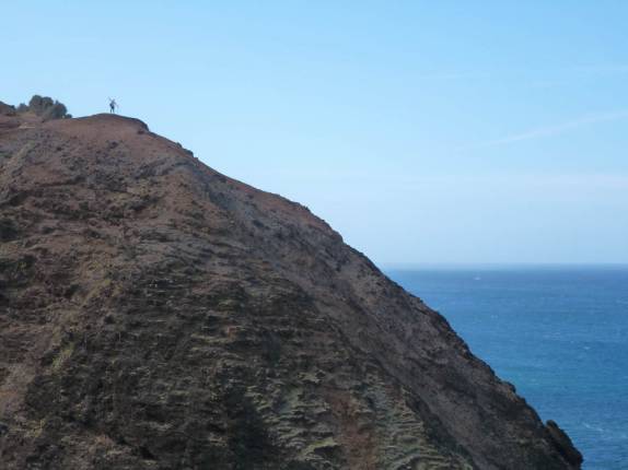 A Ana quase desaparece na grandiosa paisagem ao longo da trilha do Kalalau, na Na'Pali Coast, na costa norte de Kauai, no Havaí